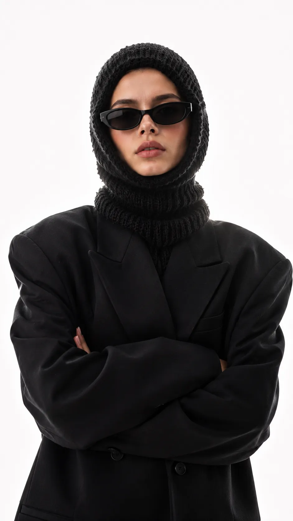 Minimal luxury fashion campaign portrait featuring a stylish woman in avant-garde winter accessories and black designer clothing.