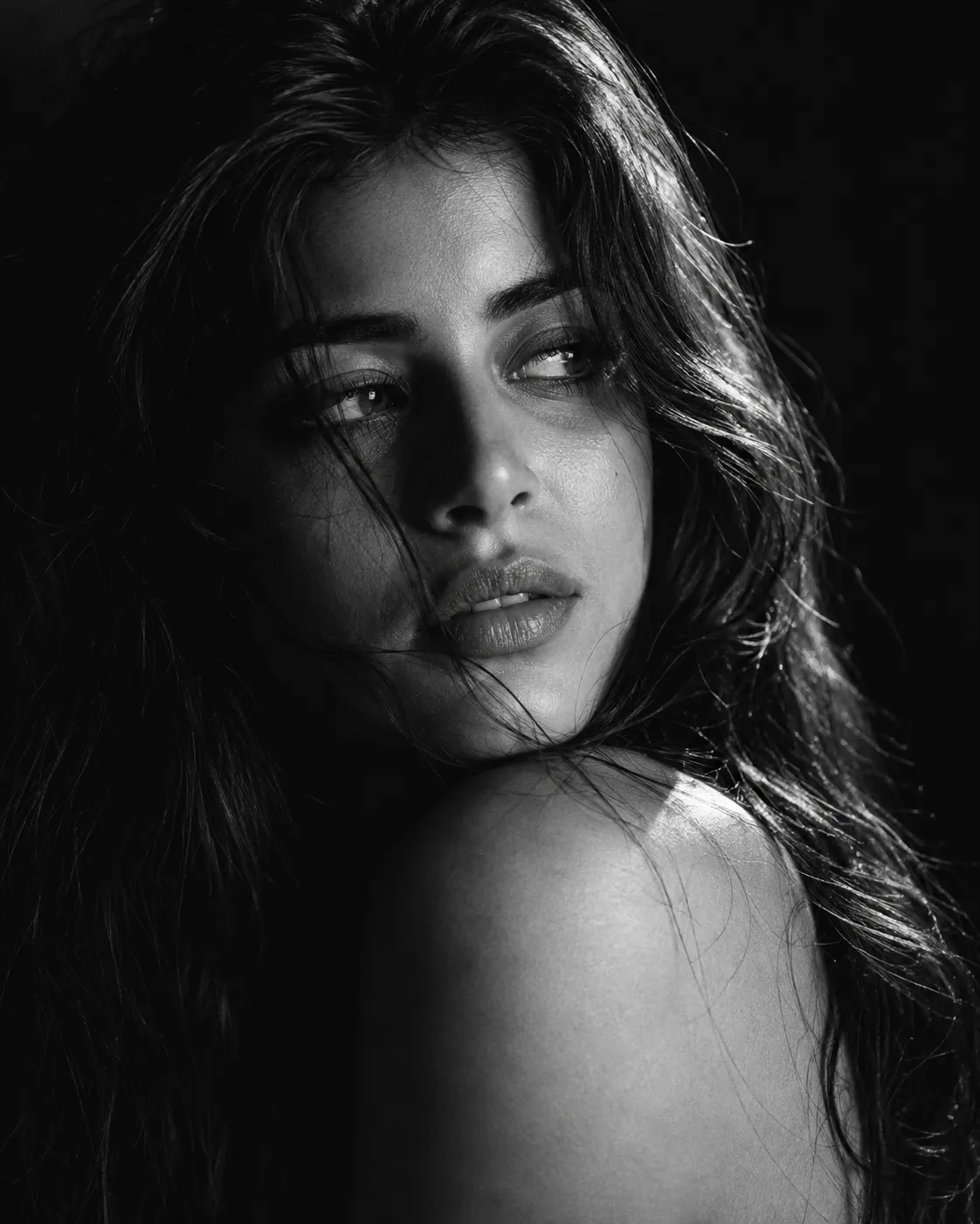 Female dramatic black and white close-up portrait looking over shoulder