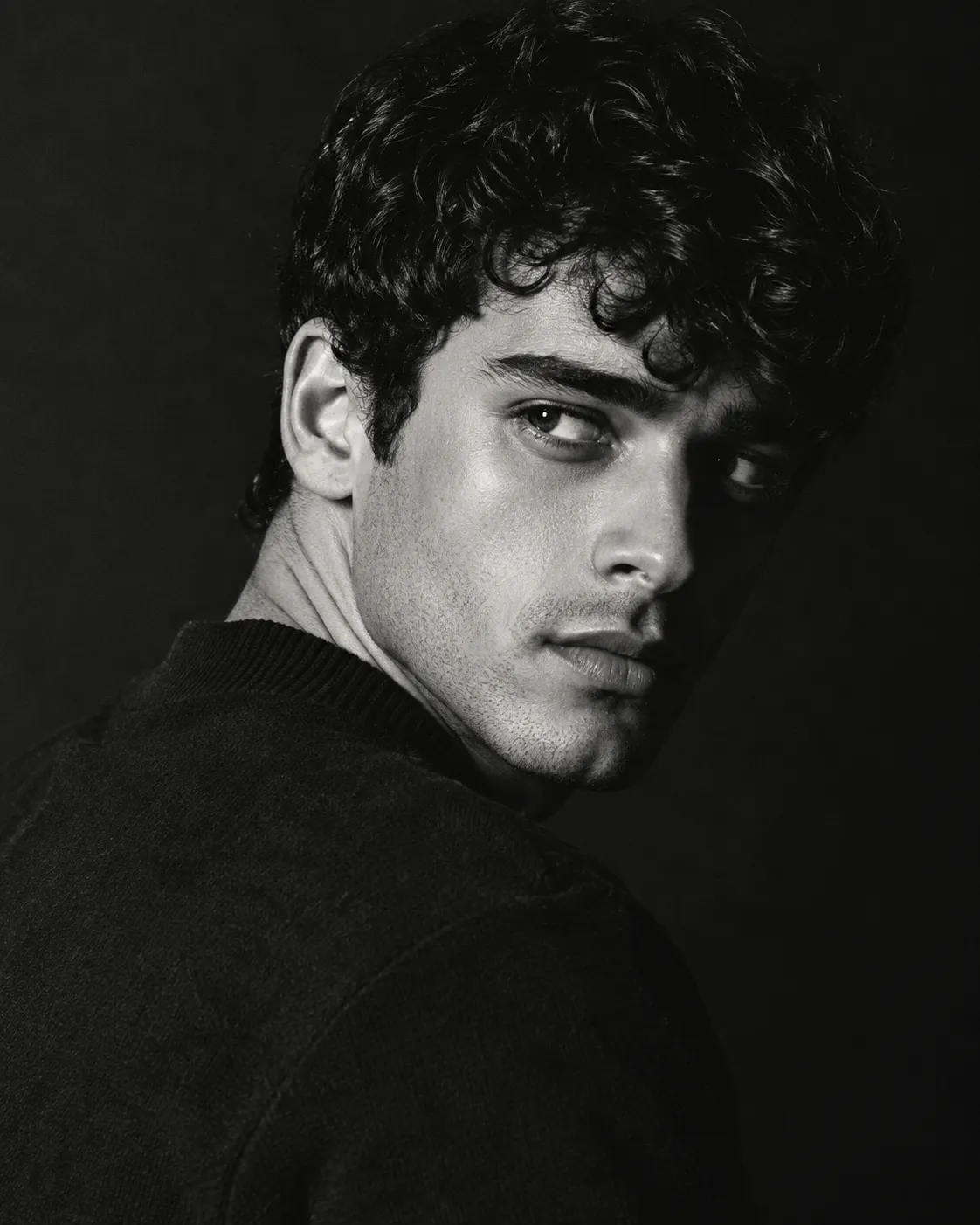 Male dramatic black and white close-up portrait looking over shoulder